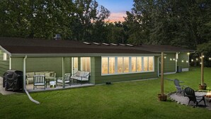 Une maison dotée d’un patio couvert, d’un espace salon extérieur et d’une pelouse.