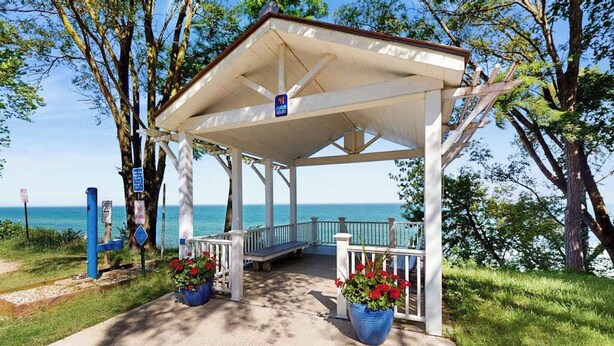 A covered pavilion with a view of the sea, a wooden deck, and potted plants. - Rustic beach cottage with partial lake views, grill, & WiFi - great location (Michiana)