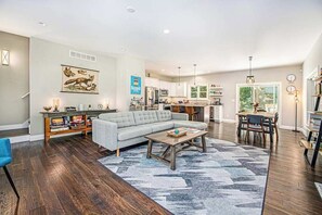 A spacious living area with a sofa, coffee table, and a rug.