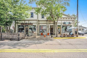 A building with a storefront labeled 'New Holland Spirits' and another with a sign for 'Spal's Place.' - Riverfront Home w/Private Deck/River Views/Free WiFi - Near Restaurants/Marina (Saugatuck)