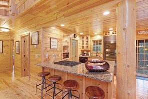 A wooden interior with a kitchen area, bar stools, and a sign reading 'LAKE'.