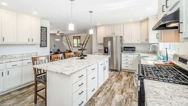A modern kitchen with white cabinetry, a central island, stainless steel appliances, and pendant lighting. - Four-season retreat with fireplace, firepit, grill, WiFi & central AC (Thompsonville)