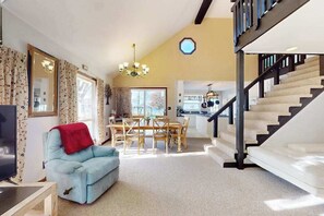 Un salon avec un canapé, une table à manger et un escalier.