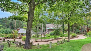 A park with a gazebo, walking paths, and a building with a green roof. - Single-level condo with a full kitchen, & washer/dryer (Glen Arbor)