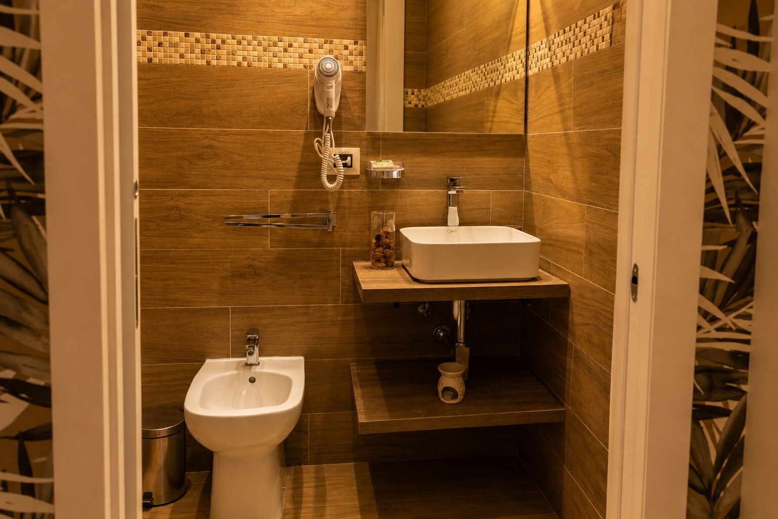 A bathroom with a bidet, a sink, and a shower.