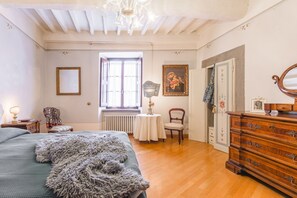 Ein Schlafzimmer mit Bett, Kommode und einem Fenster mit Blick.