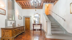 A grand hallway with a wooden floor, a staircase, a chandelier, and a large mirror. - Palazzo Simonetti - a noble elegance in the heart of Cortona (Cortona)