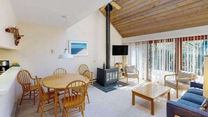 Een gezellige woonkamer met een open haard, houten meubels en een groot raam met gordijnen.