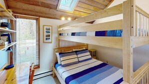 A bunk bed room with a skylight, wooden ceiling, and a desk with a chair. - River-view condo on Crystal River with loft, deck, community firepit & fireplace (Glen Arbor)