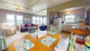 Ett kompakt bostadsutrymme med en matplats, ett litet kök och en sittgrupp.