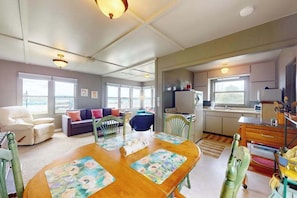 Un espacio habitable compacto con comedor, kitchenette y zona de estar.