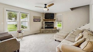 A living room with a fireplace, a ceiling fan, and a large window. - Arcadia Retreat w/ private hot tub, gas grill, fire pit, near beach, Dogs- YES! (Arcadia)