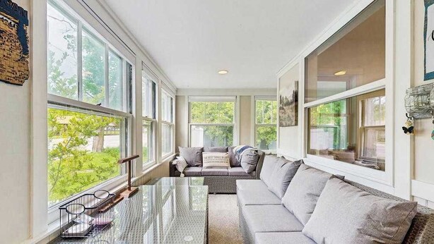 A sunroom with large windows, a glass coffee table, a gray sofa, and a wicker chair. - Arcadia Retreat w/ private hot tub, gas grill, fire pit, near beach, Dogs- YES! (Arcadia)