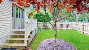 A residential property with a front yard, a white picket fence, and a driveway leading to a garage. - Dog-friendly home in the perfect location with enclosed yard, streaming, & W/D (Union Pier)