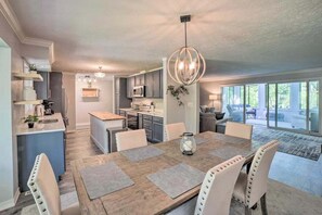 A modern kitchen with a dining area, large windows, and a chandelier. - Serene Home with Fire pit, Gas Grill, WIFI & Close to Beach (Three Oaks)