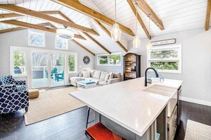 A spacious living area with a large island, wooden beams, and a view of Lake Michigan. - Fully-renovated lakefront home with beach cabana, association beach, & firepit (Lakeside)