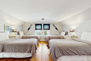 A bedroom with two beds, a window with blinds, a ceiling fan, and a nightstand with a lamp. - Enjoy a scenic getaway, a relaxing hot tub, and seasonal comfort. (New Buffalo)