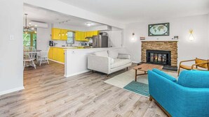 Ein modernes Wohnzimmer mit einer Couch, einem Couchtisch und einem Kamin.