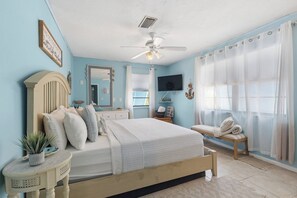 A bedroom with a bed, a vanity, a television, and a window with curtains. - Blue Lagoon 2bed/2bath with private pool - no dockage (Marathon)