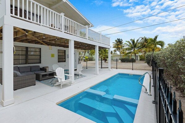 A poolside area with a covered seating area, a pool, and a fenced yard. - Blue Lagoon 2bed/2bath with private pool - no dockage (Marathon)