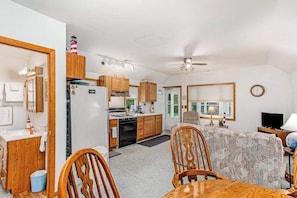 A compact living space with a kitchen, dining area, and a single bedroom.