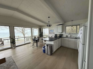 Een ruime keuken met grote ramen, een eethoek en uitzicht op zee.