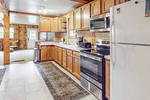 A kitchen with wooden cabinets, stainless steel appliances, and a white refrigerator.
