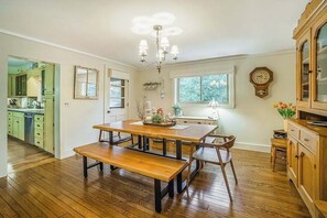 A dining area with a wooden table, benches, and a chandelier. - Terrific riverfront home near the slopes w/ firepit, free WiFi & five-acre lot (Thompsonville)