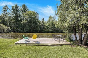 Outdoor dining - Riverfront cabin with furnished deck, beautiful backyard, firepit & kayaks (Honor)