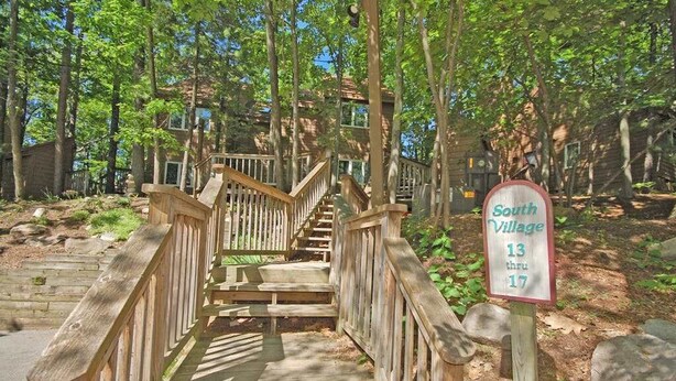 Un escalier en bois menant à un bâtiment portant l’inscription « South Village, des numéros 13 à 17 ».