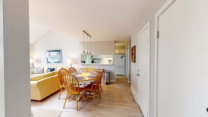 A compact living space with a dining area, a kitchen, and a living room. - Beautiful beachfront townhouse with deck, water views, community firepit (Glen Arbor)