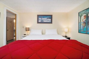 A hotel room with a bed, two bedside tables, a door, and a painting on the wall.