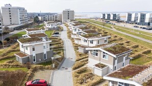 A modern residential area with compact housing, green roofs, and a clear view of the surrounding landscape. - Cozy Holiday Apartment with Limited Sea View near the Beach in Wendtorf (Wendtorf)