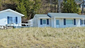 A two-story house with a flat roof, a front porch, and a small deck.