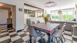 A dining area with a checkered floor, a table with a floral tablecloth, and a sofa in the background. - Holiday Home "Louvanna" with Luberon View, Wi-Fi, and Air Conditioning (Taillades)