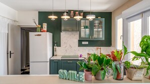 A modern kitchen with a green backsplash, white cabinets, a white refrigerator, and pendant lights. - Holiday Home "Louvanna" with Luberon View, Wi-Fi, and Air Conditioning (Taillades)