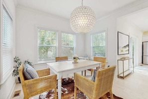 A dining area with a white table, wicker chairs, a cowhide rug, and a hexagonal pendant light. - South Haven retreat w/ access to Harbor Club Resort amenities (South Haven)