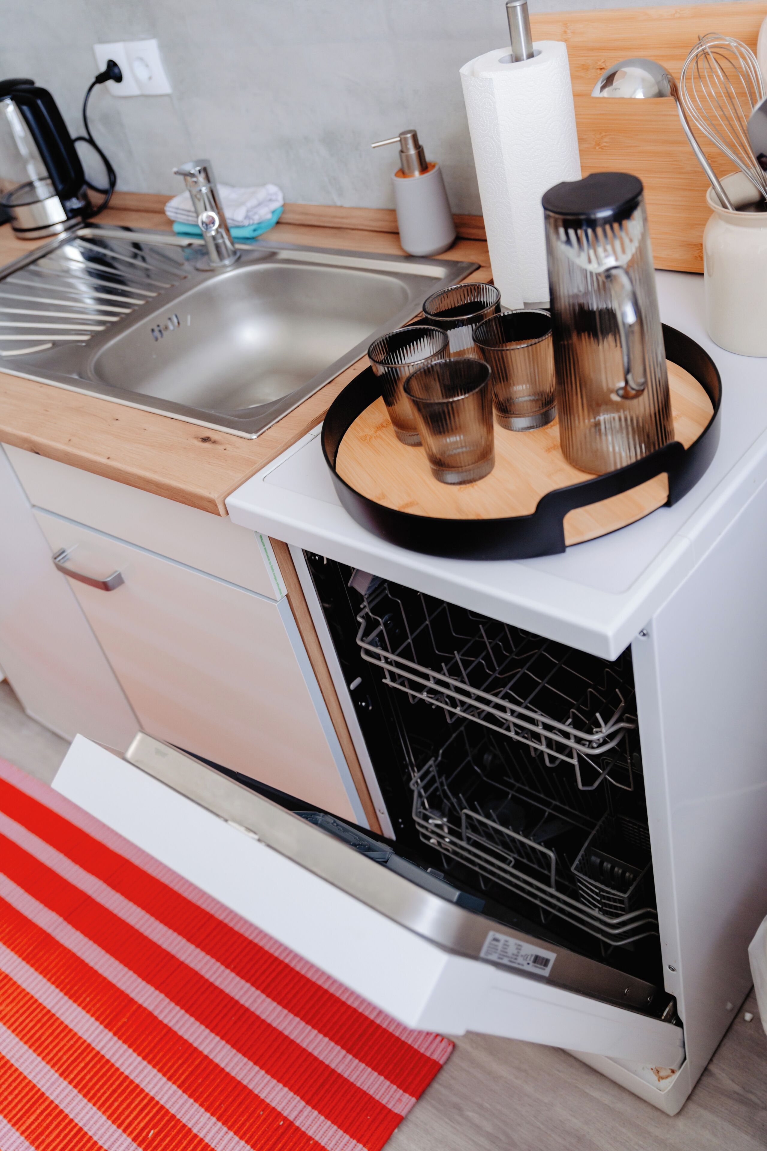 Una cucina con lavello in acciaio inossidabile, scolapiatti, macchina da caffè e tostapane.