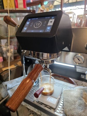 Una cafetera con pantalla digital, temporizador y espumador de leche.