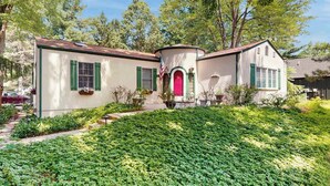 A two-story house with a red door, green shutters, and a small porch area. - Dog-Friendly Home with Enclosed Yard & Free High-Speed WiFi - Great Location (Union Pier)