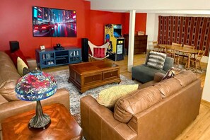 A living room with a TV, sofa, coffee table, and a colorful lamp.