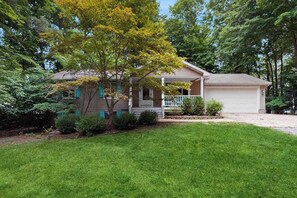 A single-story house with a front porch, a garage, and a well-maintained lawn.