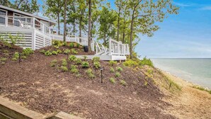 A coastal property with a wooden deck, a white railing, and a view of the sea. - The Oasis at Forest Beach | Updated house in New Buffalo with shared amenities (New Buffalo)