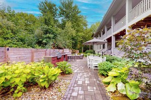 A patio with a grill, outdoor seating, and a covered area with string lights. - Spacious home with game room, hot tub, fireplace, fast WiFi & home theater (St. Joseph)