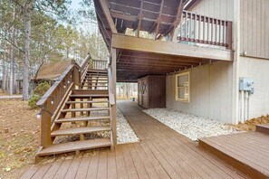 A wooden deck leading to a cabin with a staircase and a covered area. - Spacious Home with deck, grill  & added Crystal Mountain Amenities (Thompsonville)