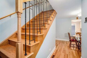 Una escalera de madera con barandillas negras que lleva a una plataforma.