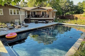 Une piscine avec des chaises longues et un espace aménagé autour.