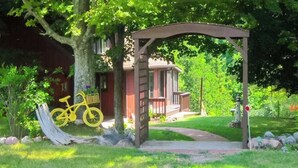 A wooden pergola with a pathway leading to a house. - Riverfront Cabin with Stunning Views, Fire pit, Gas Grill & WIFI (Thompsonville)