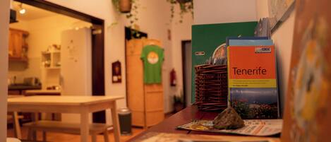 Un comedor con una mesa, sillas, un mapa y un libro titulado 'Tenerife' sobre la mesa.