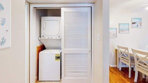 Una habitación compacta con lavadora, secadora y comedor con sillas.